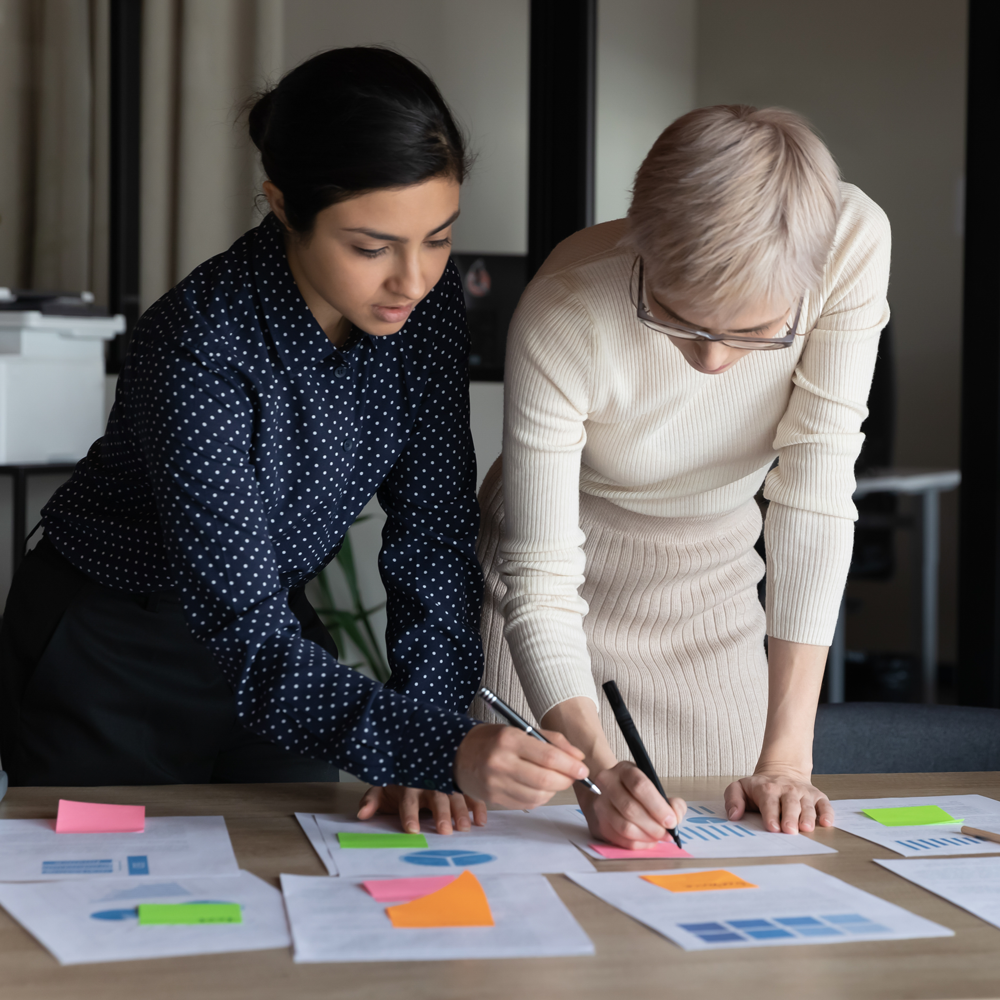 Two business women brainstorming together with colorful post it notes